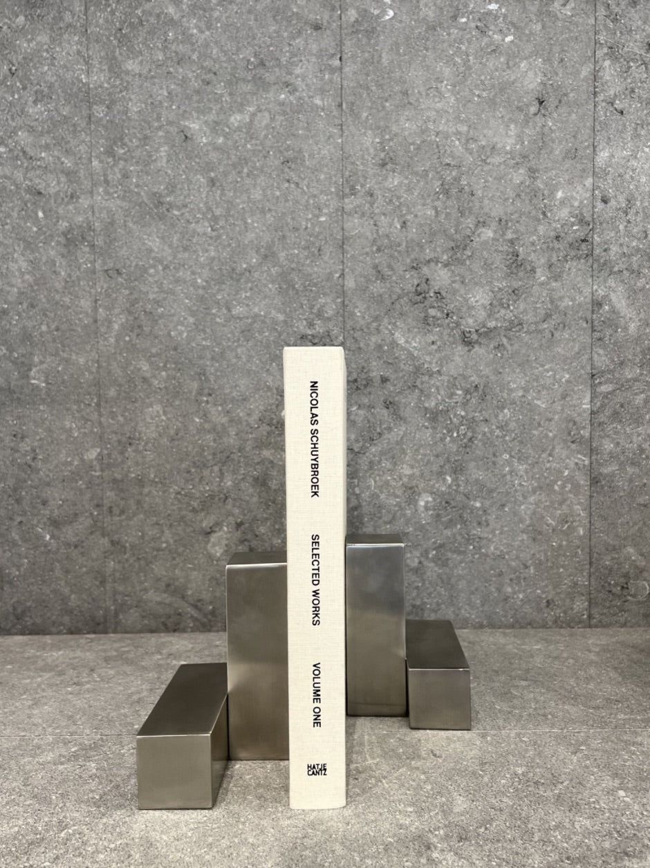 Pair of pewter bookends designed by Nicolas Schuybroek  
Minimalist pewter bookends with sculptural form  
Solid pewter bookends on a modern bookshelf  
Architectural bookends in brushed pewter finish  
Contemporary metal bookends by Belgian designer  
Close-up of Nicolas Schuybroek pewter bookends  
Elegant, heavy-duty bookends in minimalist style  
Designer bookends on a desk with stacked books  
Monolithic pewter bookends styled in a modern interior  
Sculptural pewter objects used as functional bookends