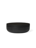 Minimalist black ceramic jars with wooden lids, part of Vincent Van Duysen's home accessories collection.