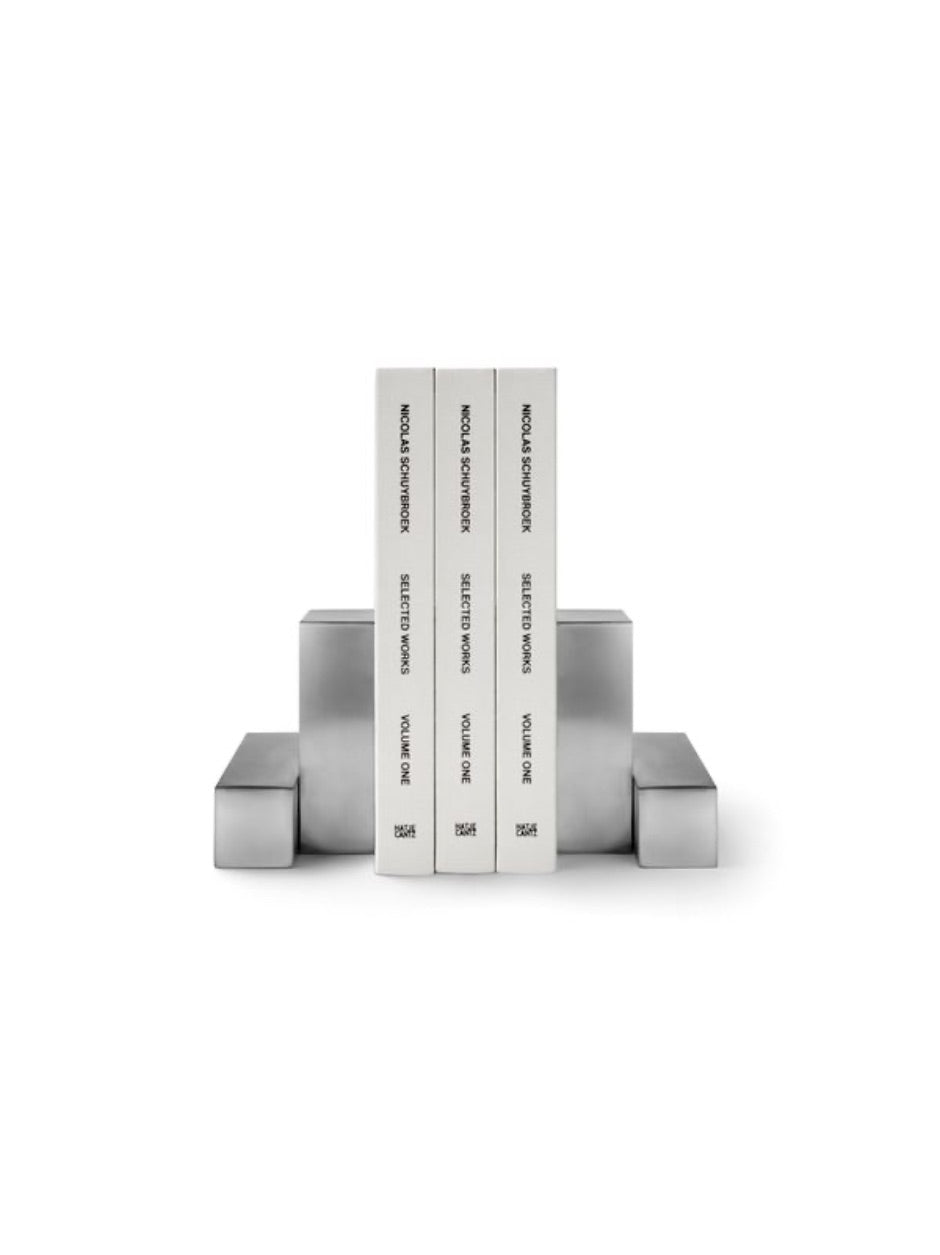 Pair of pewter bookends designed by Nicolas Schuybroek  
Minimalist pewter bookends with sculptural form  
Solid pewter bookends on a modern bookshelf  
Architectural bookends in brushed pewter finish  
Contemporary metal bookends by Belgian designer  
Close-up of Nicolas Schuybroek pewter bookends  
Elegant, heavy-duty bookends in minimalist style  
Designer bookends on a desk with stacked books  
Monolithic pewter bookends styled in a modern interior  
Sculptural pewter objects used as functional bookends